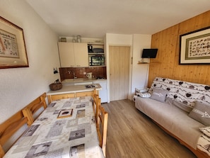 A compact living space with a kitchenette, a dining area, and a sofa. - Cozy apartment, balcony with slopes view - 4 guests (Montgenèvre)