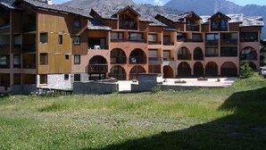 A multi-story hotel with a central courtyard, surrounded by mountains. - Cozy apartment, balcony with slopes view - 4 guests (Montgenèvre)