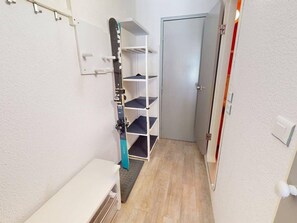 A narrow hallway with a white door, a white wall with a shelf unit, and a white counter. - Ski-in/ski-out apartment, exceptional view - 6 guests (Les Arcs)