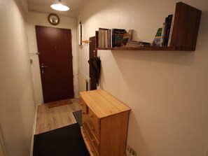 Ein Flur mit einer hölzernen Bank, einer Tür und einem Bücherregal.
