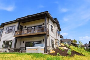 Ein zweistöckiges Haus mit Balkon, Garage und gepflegtem Rasen.