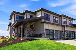 A modern two-story house with a stone facade, large windows, and a covered porch. - Luxury 4BR | Free Ski Shuttle | Hot Tub | Deer Valley (Heber City)