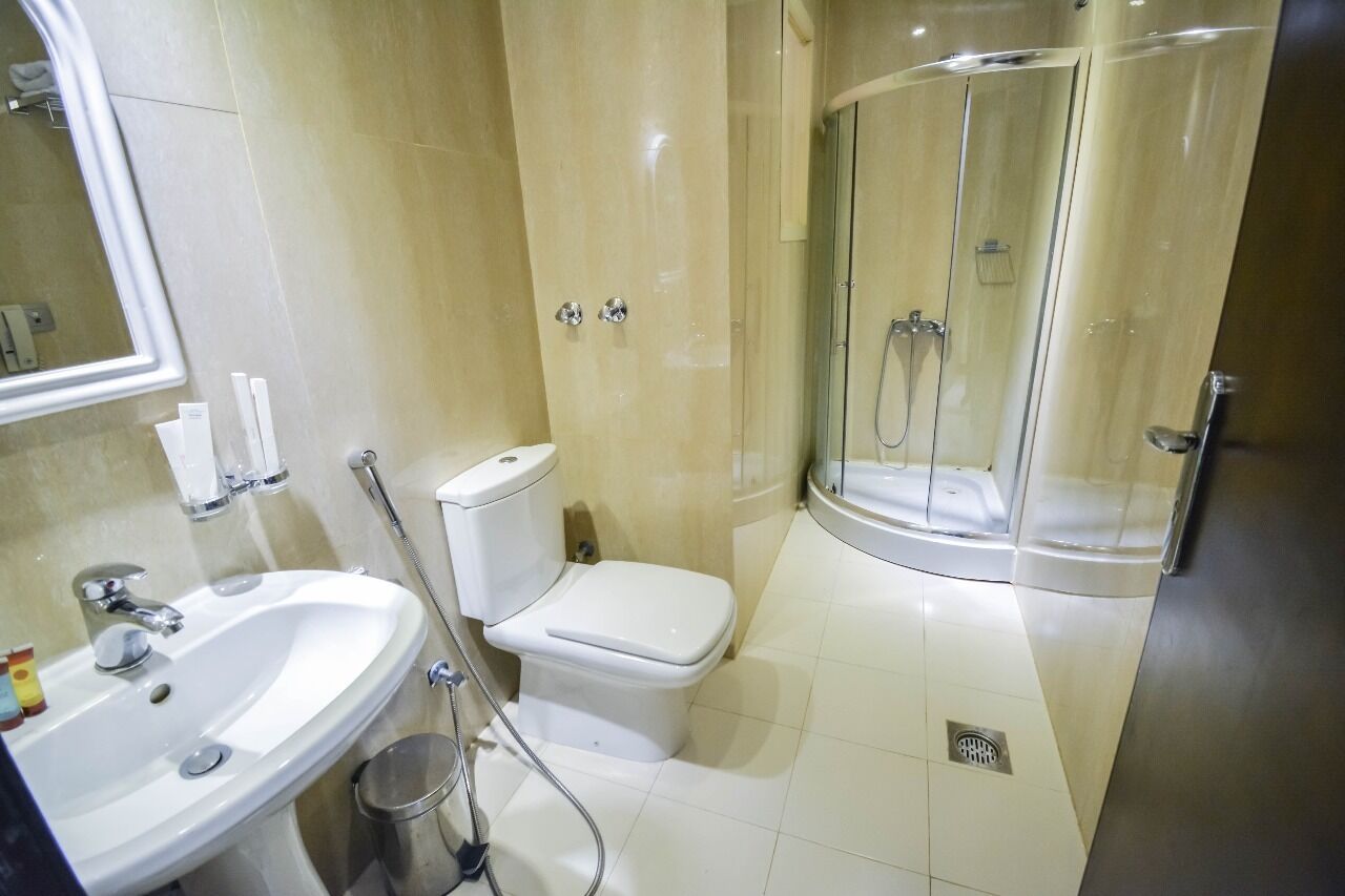 A bathroom with a sink, toilet, and a glass-enclosed shower.