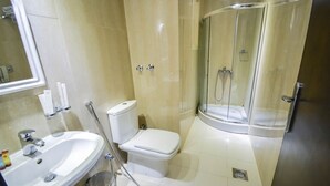 A bathroom with a sink, toilet, and a glass-enclosed shower. - Reef Global Hotel Al Maabda (Makkah)