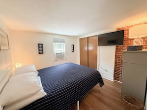 A bedroom with a bed, a wardrobe, a television, and a window. - Nautical three bedroom sleeping 6 in West Dennis! (West Dennis)