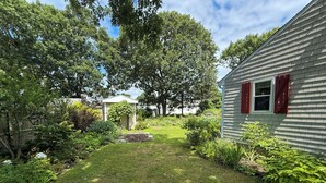 Un immobile residenziale con un prato curato, un piccolo giardino e un capanno.