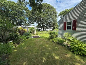 A residential property with a well-maintained lawn, a small garden area, and a shed. - Nautical three bedroom sleeping 6 in West Dennis! (West Dennis)