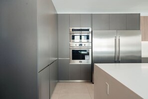 A modern kitchen with stainless steel appliances, including a built-in oven and a refrigerator. - Ocean View | 5BR Staffed Resort Villa by Bocobay (St. Ann’s Bay)