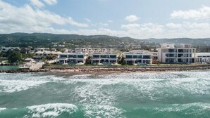 Un hôtel situé sur la côte, composé de plusieurs bâtiments, avec un rivage rocheux et une vue sur la mer.