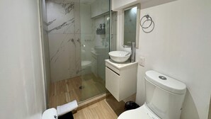 A modern bathroom with a glass-enclosed shower, a white sink, and a toilet. - w Enchanting 1BR in Prime Polanco (Mexico City)