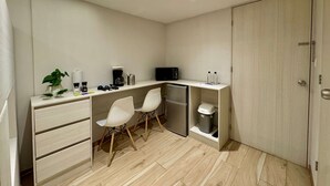 A compact kitchenette with a microwave, coffee maker, and two chairs. - w Enchanting 1BR in Prime Polanco (Mexico City)