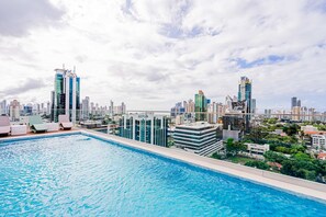 A rooftop pool with lounge chairs and a city skyline in the background. - w Upscale 1BR w AC in Vibrant Obarrio (Panama City)