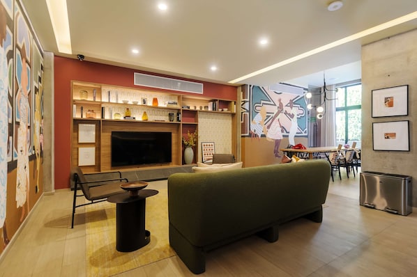 Uma sala de estar moderna com sofá, televisão, lareira e área de jantar.