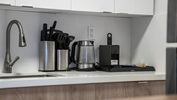 Una cocina moderna con un grifo de acero inoxidable, una cafetera y un tostador.