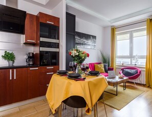 Eine moderne Küche mit Holzschränken und einem Essbereich mit gelbem Tischlein.