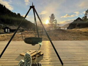 Eine Holzterrasse mit einer hängenden Schaukel und einer Metallschüssel.