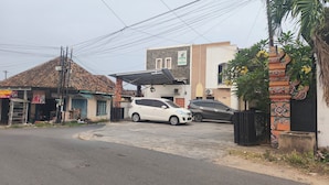 A street view with a building labeled 'Hostel of Tuwuh2' and parked cars.