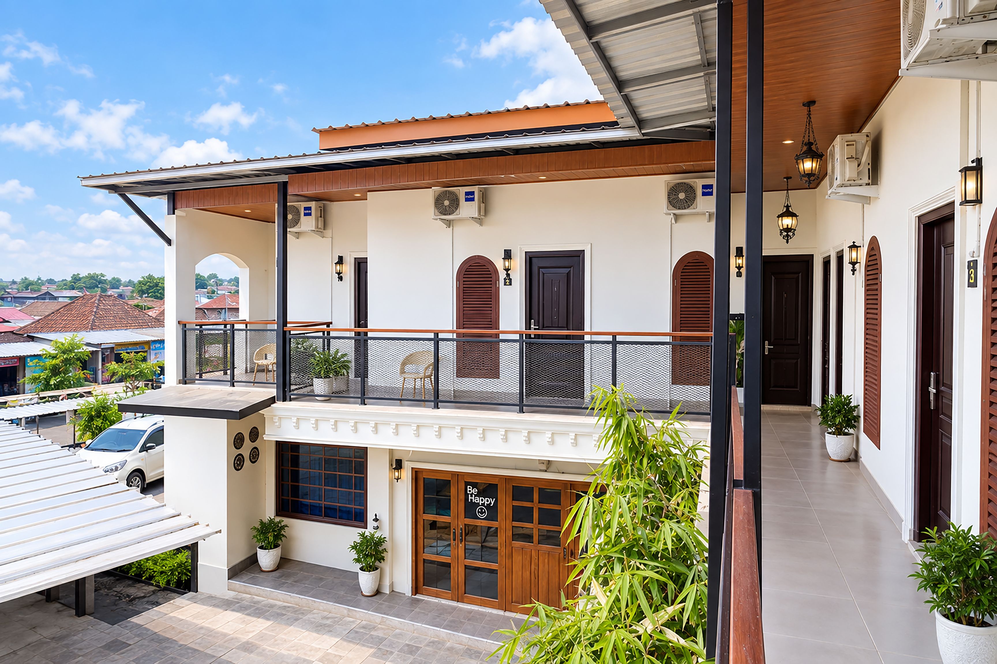 A two-story building with a balcony, a garage, and a covered outdoor seating area.