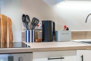 A kitchen counter with a coffee maker, a sink, and a dish soap dispenser. - Modern 2BR Apt in Leeds Arena Uni City Hub Stay (Leeds)