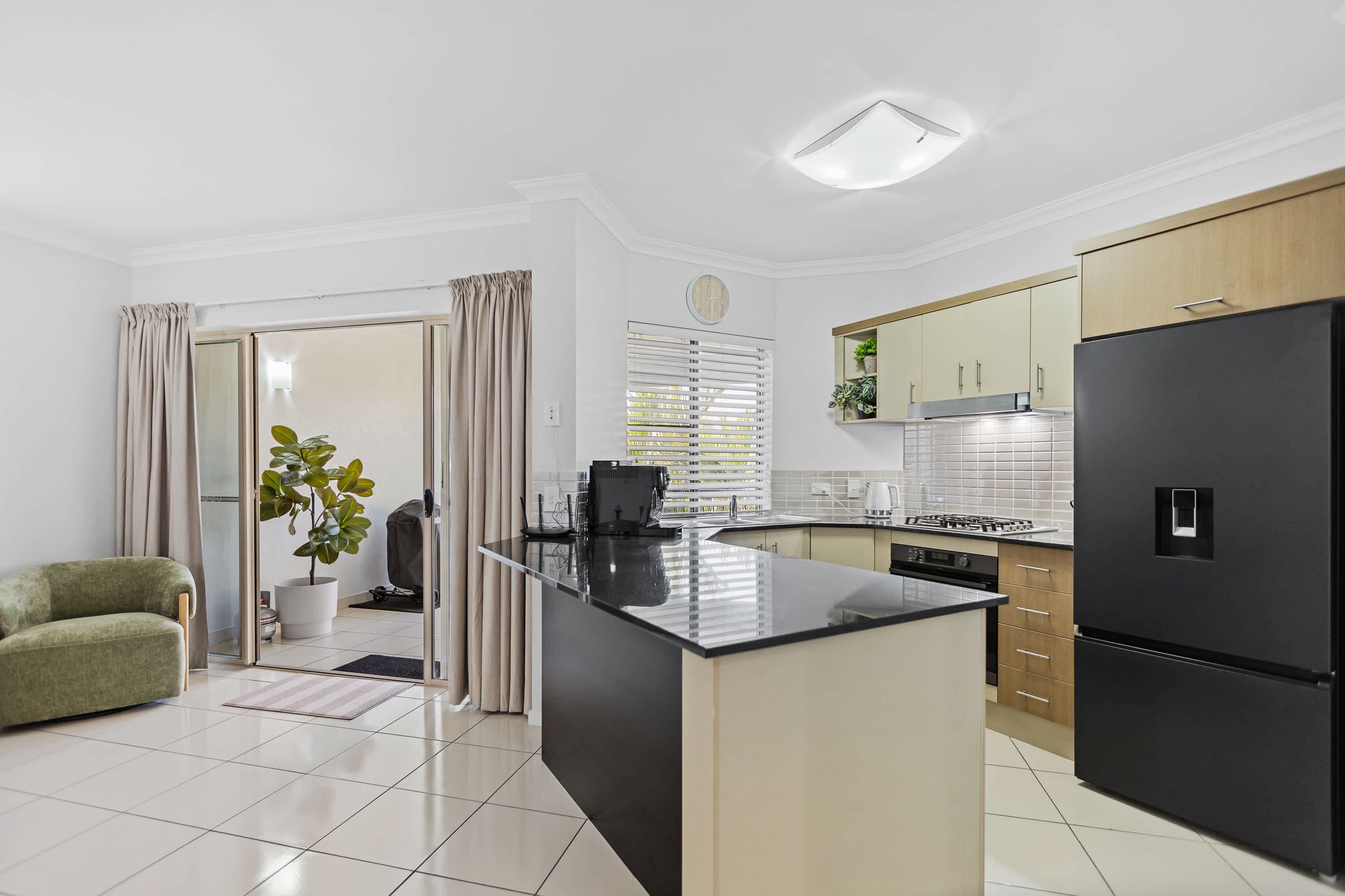 A modern kitchen with a central island, a refrigerator, and a stove.