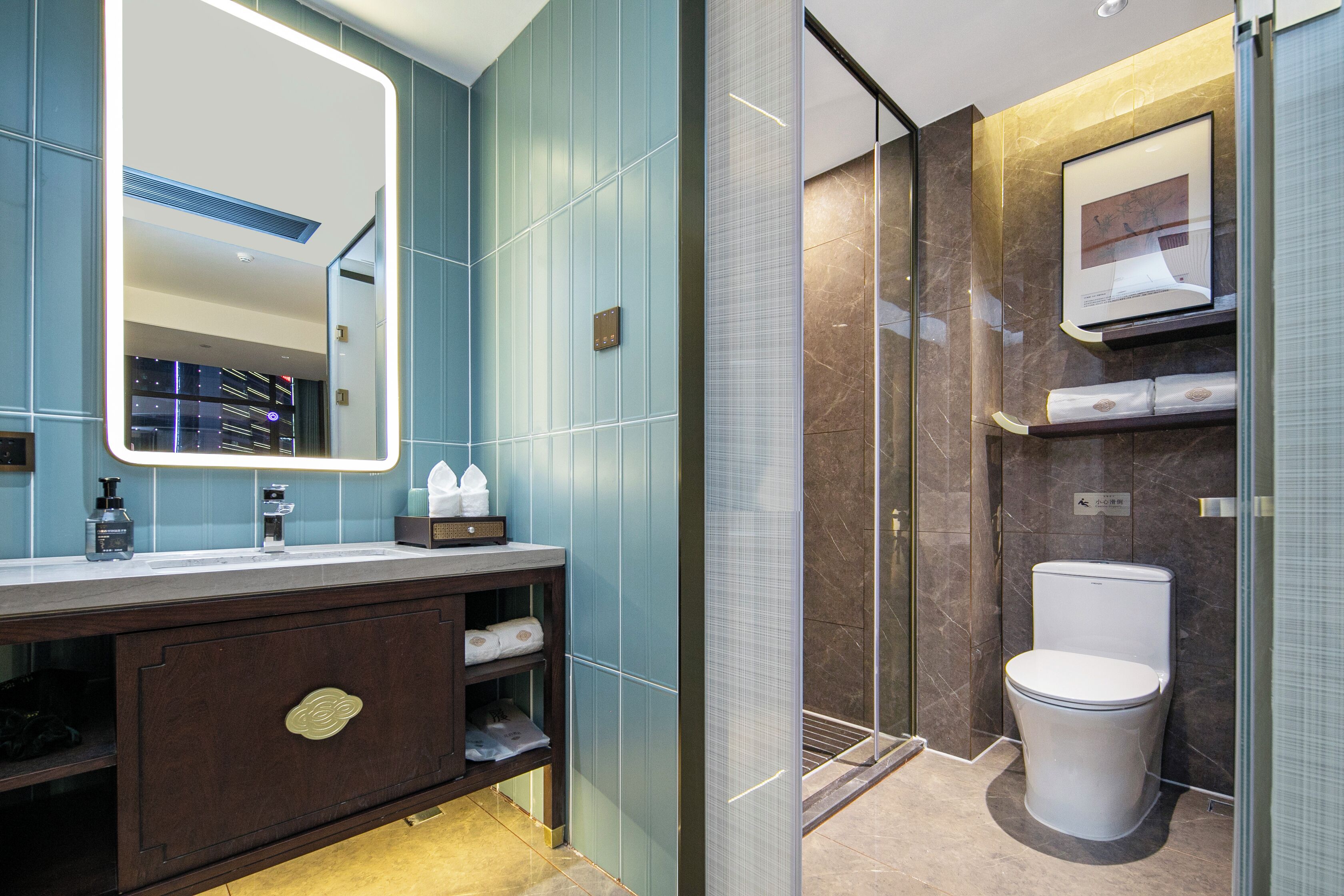 Un baño moderno con un espejo grande, un tocador con armario de madera oscura, un inodoro y una cabina de ducha de vidrio.