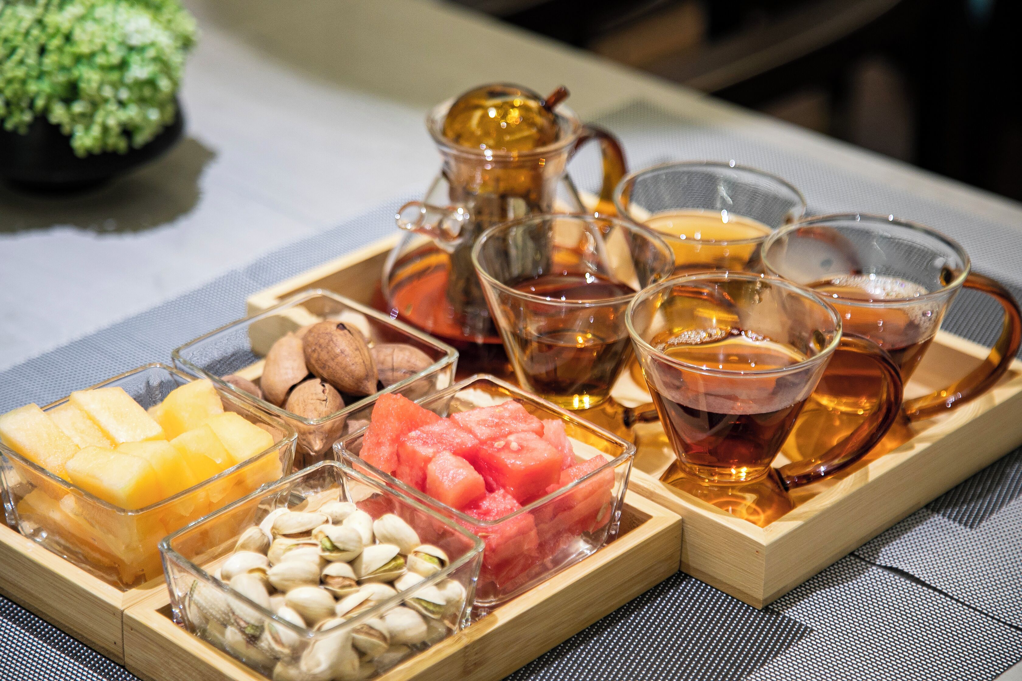 Una bandeja con diversos alimentos y vasos de té.