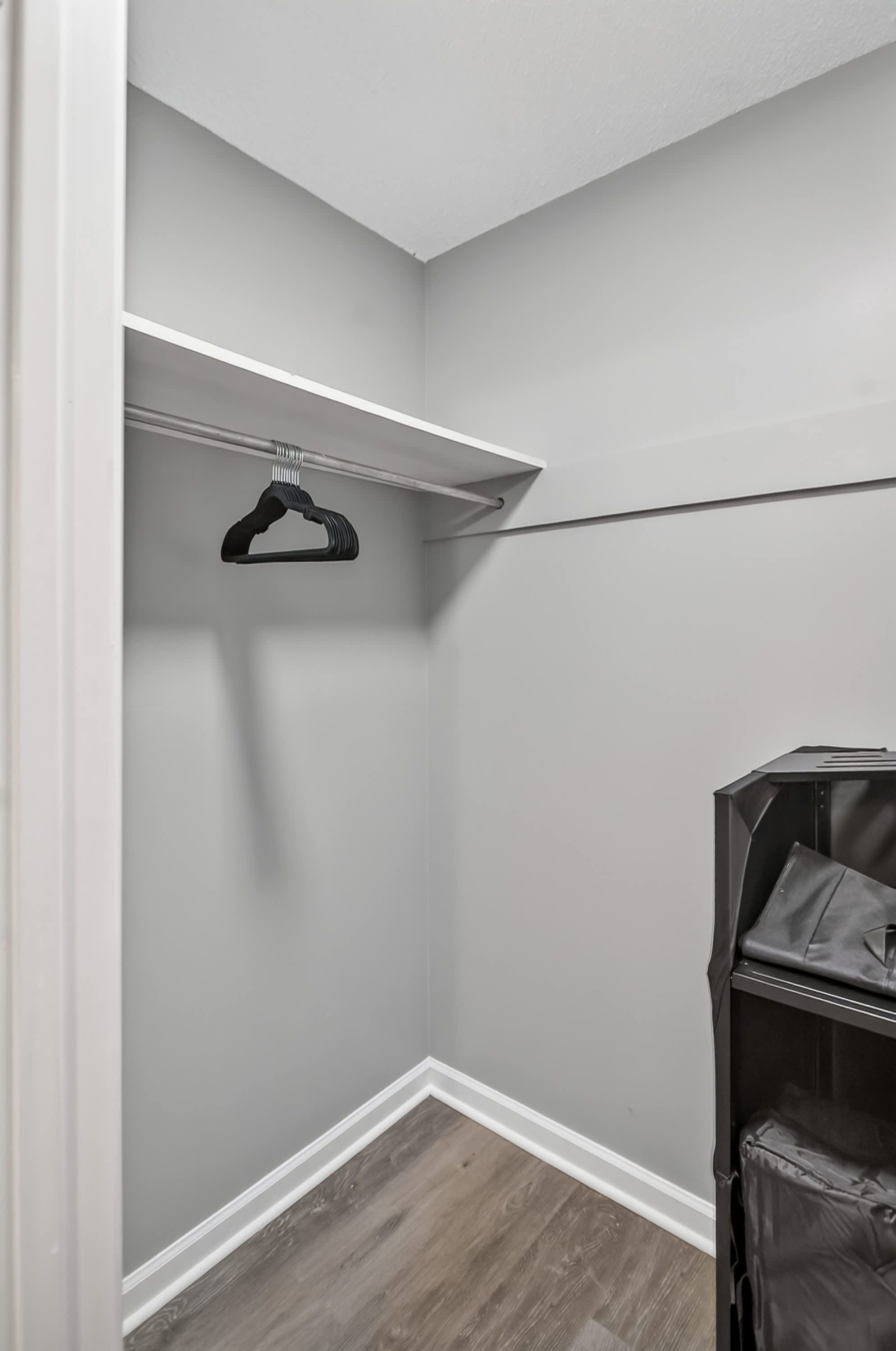 A closet with a hanging rod and a storage unit.