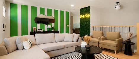 A modern living room with a sectional sofa, a round coffee table, and a striped rug.