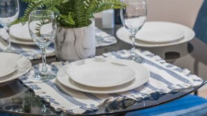 A dining table set with plates, glasses, and a potted fern. - Stylish 2BR Apt Near City Centre - 2 Ensuites Wifi (Birmingham)