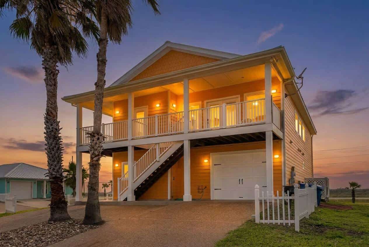 Une maison à deux étages avec un balcon, un escalier et un garage.