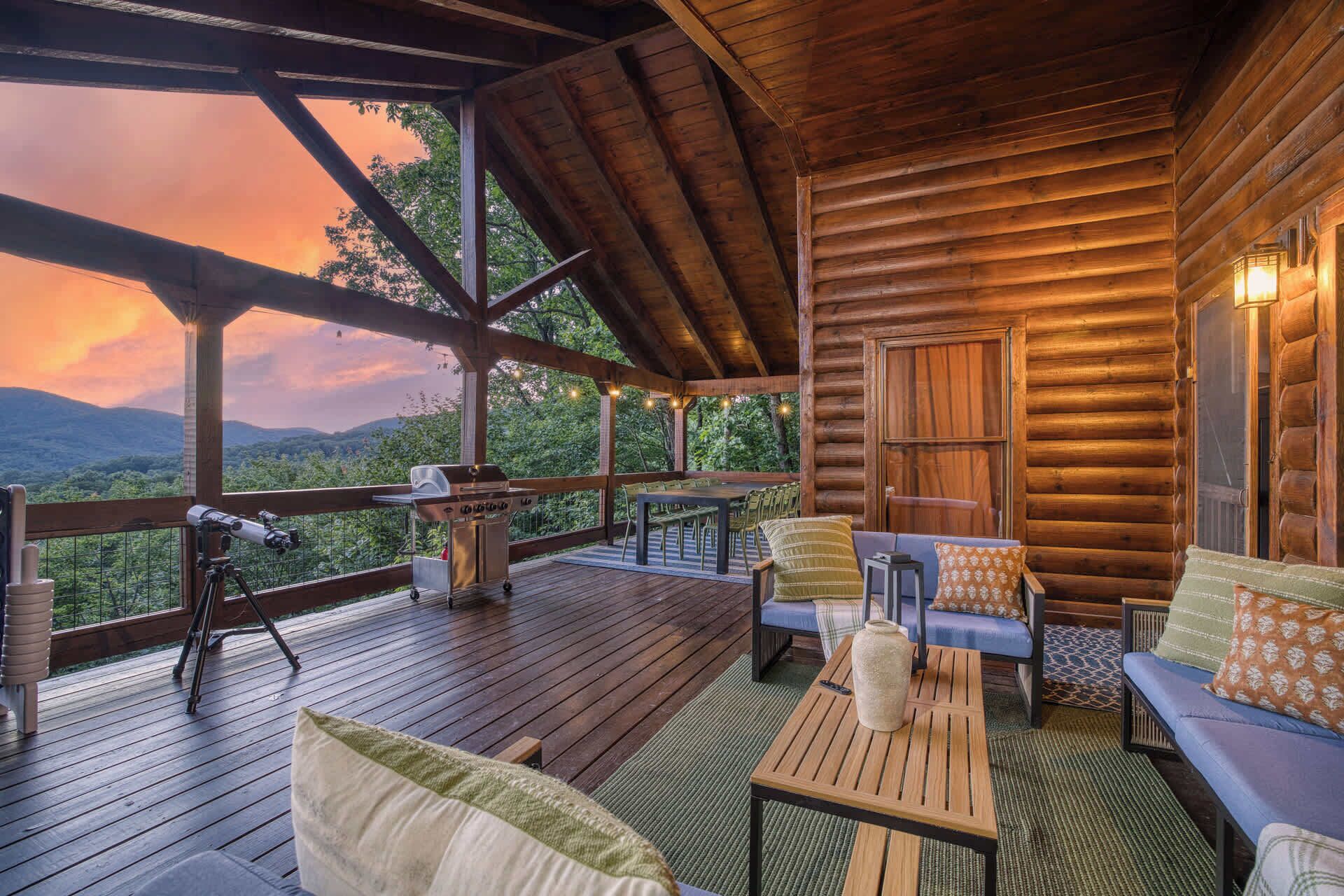 A wooden deck with a grill, seating area, and a view of the mountains.