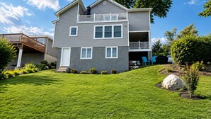 A two-story house with a covered porch and a landscaped lawn. - Lux Lakeview Experience Sleep 8 (Hopatcong)