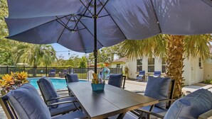 An outdoor patio with a pool, a table, and chairs. - Cayuga Clubhouse • Poolside Fun & Game Room (Jacksonville)