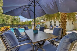 Eine Außenpatio mit Pool, Tisch und Stühlen.
