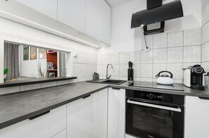 A modern kitchen with a dishwasher, kettle, and coffee maker. - House in Landunvez Near Penfoul Beach (Warsaw)