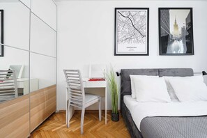 A modern bedroom with a bed, a desk, and two framed cityscape photographs. - House in Landunvez Near Penfoul Beach (Warsaw)