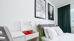 A hotel room with a bed, a desk with a mirror, and two framed pictures on the wall. - House in Landunvez Near Penfoul Beach (Warsaw)