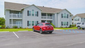 A two-story building with a parking lot in front. - Pool & Hot Tub Access! Family Condo, 5 Mi to Beach (Gulf Shores)