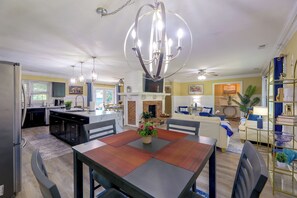 A spacious living area with a dining table, sofas, and a fireplace. - Back Deck, Grill, Yard! New Bern Family Home (New Bern)