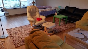 A living room with a sofa, a chair, a small table, and a pet bed. - Sleep in Filskov (Filskov)