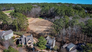 Una zona residencial con varias casas, un campo de golf y una extensa área boscosa.