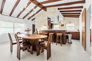 Una cucina moderna con isola centrale, sedie di legno e un tavolo da pranzo.