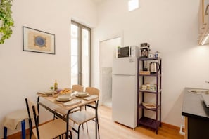 Eine kompakte Küche mit Kühlschrank, Mikrowelle und Kaffeemaschine.