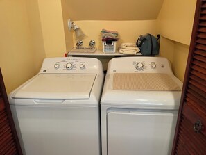 A laundry area with two front-loading washing machines and a stacked laundry basket. - Blue chalet right on the shore of Lake Brome (Lac-Brome)