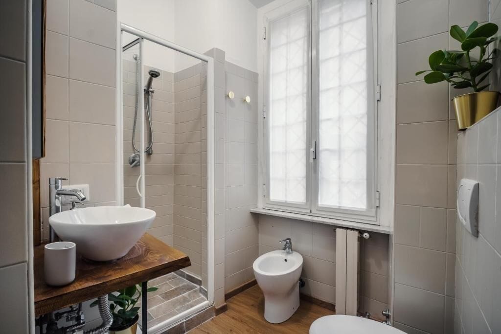 Une salle de bain avec un grand lavabo blanc, un bidet et une douche.