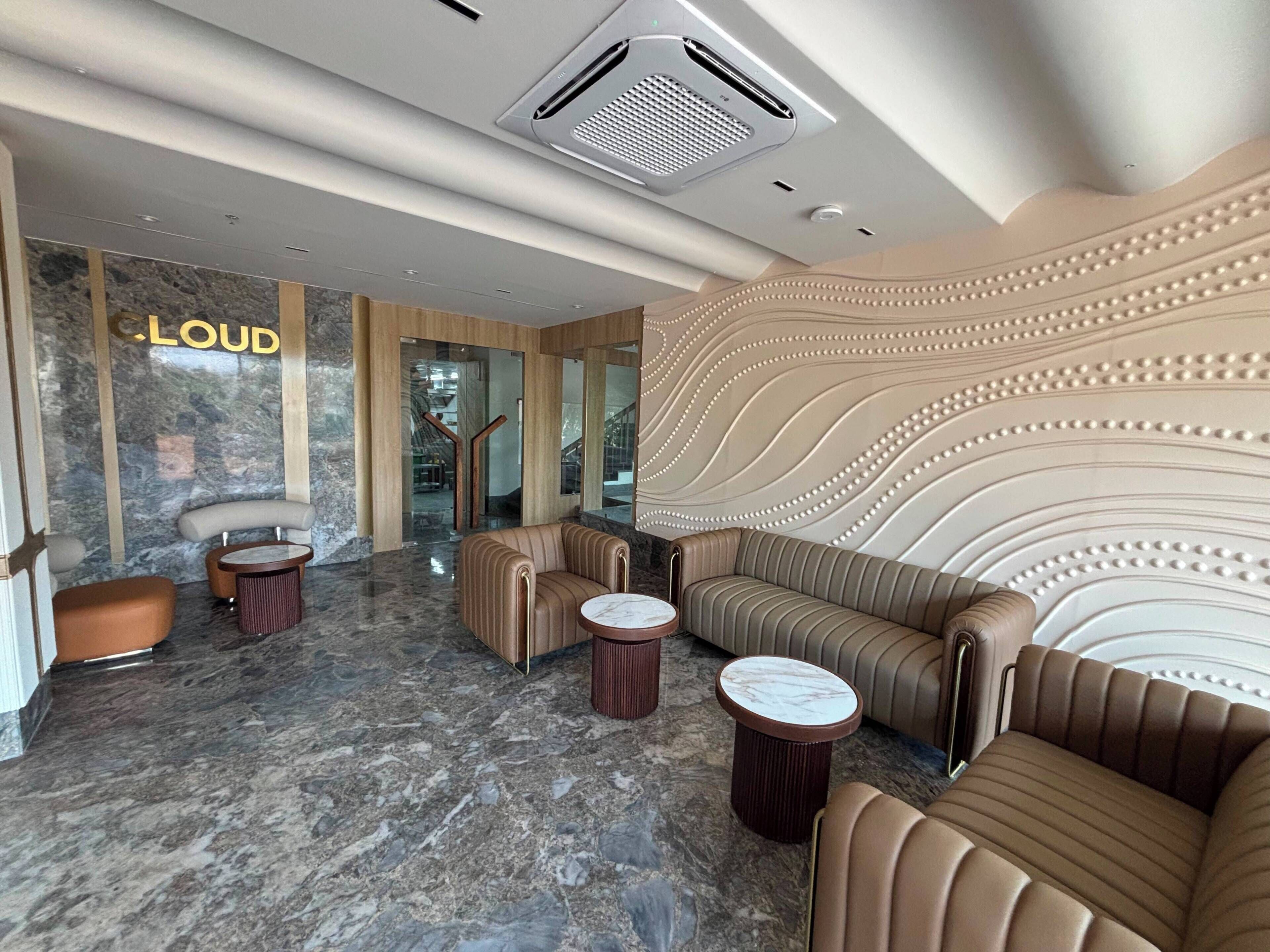A lobby with a marble floor, leather sofas, and a reception desk.