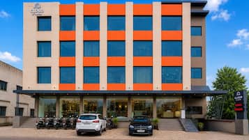 Un hotel de fachada moderna, varios pisos y cielo despejado.