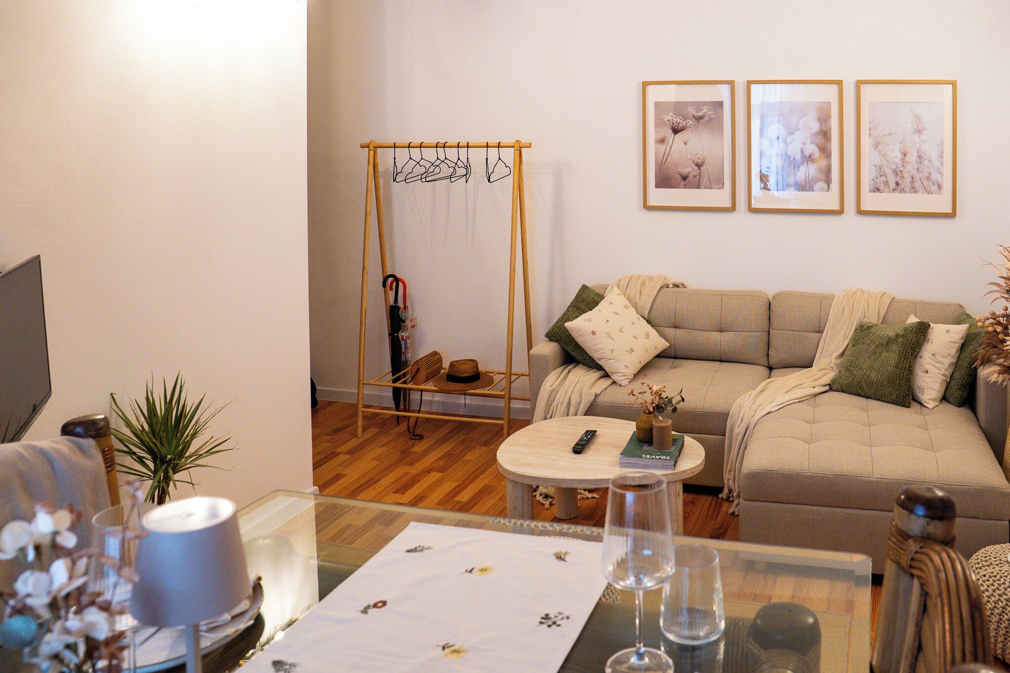 A living room with a sofa, a coffee table, a swing chair, and framed pictures on the wall.