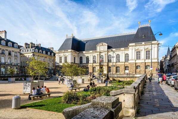 A historic building with classical architecture, a courtyard with seating, and a pedestrian bridge. - Pet-friendly Country House in Central Brittany (Saint-Vran)