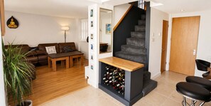 Ein modernes Wohnzimmer mit Treppe, Essbereich und Weinkühlschrank.
